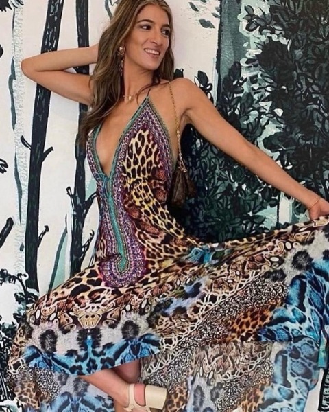 A woman wearing a stunning animal print halter dress with plunging neckline